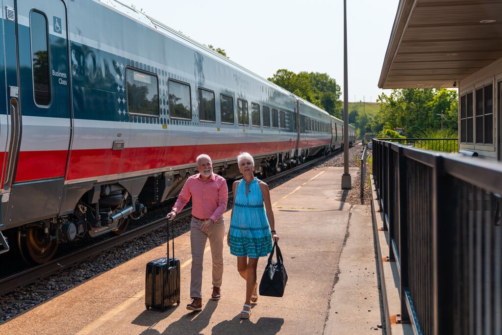 Couple walks alongside Amtrak's Missouri River Runner as they set out on a trip.