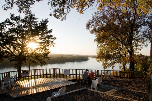 Two people drink wine on a patio overlooking the Missouri River at Les Bourgeois Vineyards near Columbia.